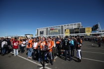 Fans enjoy the sun and pre game festivities in the converted parking lot into fan village